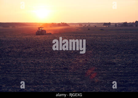 Le tracteur sur field at sunset Banque D'Images