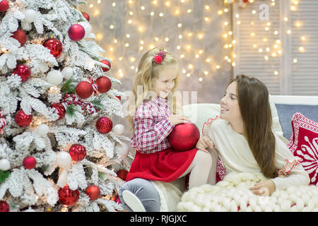 Noël décorations studio or occasionnels avec jolie fille et grand miroir avec cadre doré beaucoup présente et grand livre vert pin. Banque D'Images