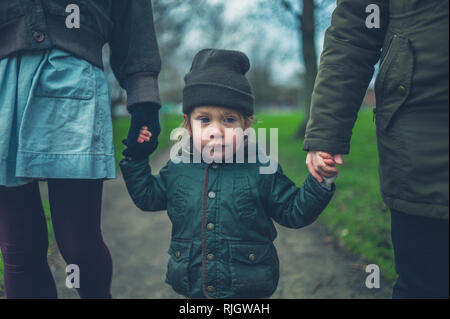 Un peu de tout-petit est la marche à l'extérieur dans un parc avec sa mère et sa grand-mère Banque D'Images