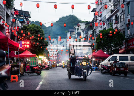 Pingxiang, Chine - Juillet 3, 2018 : marché de l'alimentation traditionnelle chinoise scène de rue avec des personnes se préparant pour la soirée d'activité intense dans la province de Guangxi bord Banque D'Images