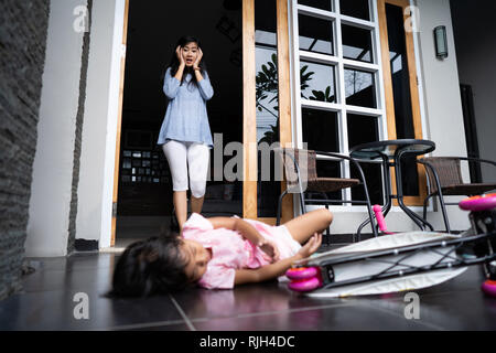 Choqué à la mère à son enfant qui est tombé de scooter Banque D'Images