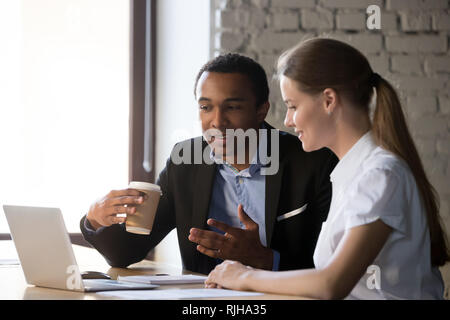 Divers employés négocier près de discuter des idées pour ordinateur portable Banque D'Images