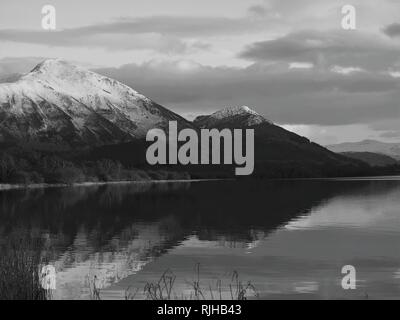 Des sommets enneigés Ullock Pike & Dodd, éclairée par le soleil qui se reflète dans le lac Bassenthwaite, Parc National de Lake District, Cumbria, Angleterre, Royaume-Uni Banque D'Images