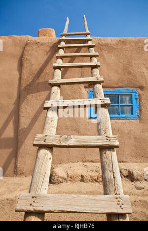 Échelle en bois contre un bâtiment d'Adobe Banque D'Images