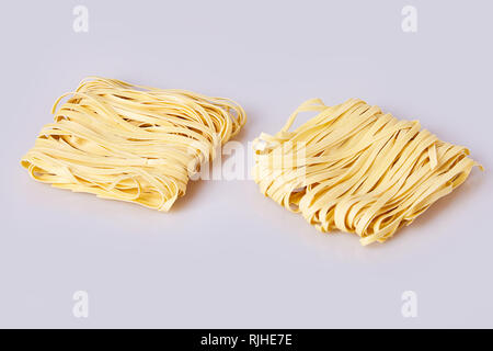 Nouilles laminées sèches d'épaisseur de forme carrée. Capelli d'angelo, les cheveux d'Ange - pâtes. Les pâtes italiennes tagliatelles faites maison. La cuisine italienne. Les nouilles aux oeufs. Banque D'Images