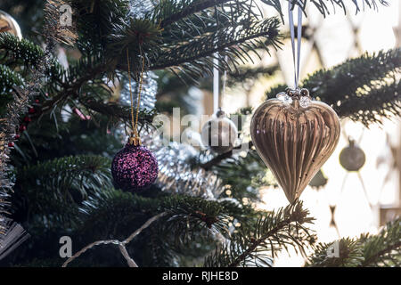 En forme de coeur d'or et des paillettes bauble hanging on Christmas Tree Banque D'Images