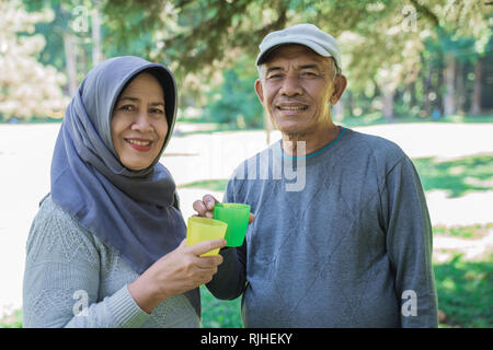 Asian senior masculins et féminins ayant un verre Banque D'Images