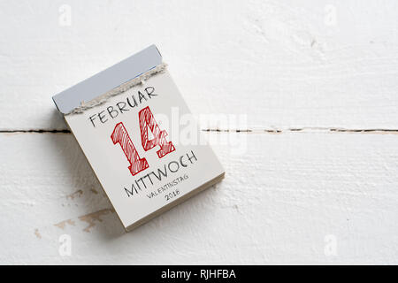 Calendrier de découpe avec 14 février (en allemand) sur le dessus sur une surface en bois Banque D'Images
