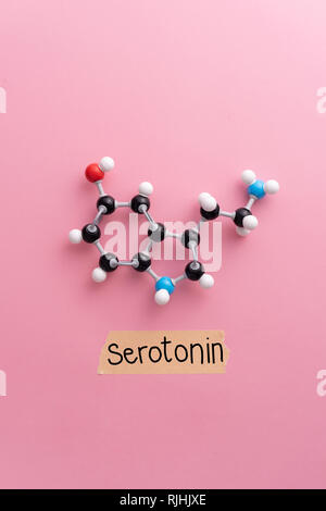 Formule chimique de la sérotonine avec 'serotonin' écrire du texte sur fond rose Banque D'Images