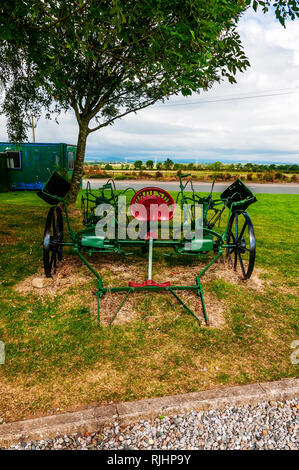 Nouvellement rénové et peint les machines agricoles reposant sur l'herbe parmi d'autres outils agricoles à proximité de la forge à Gretna Green Banque D'Images