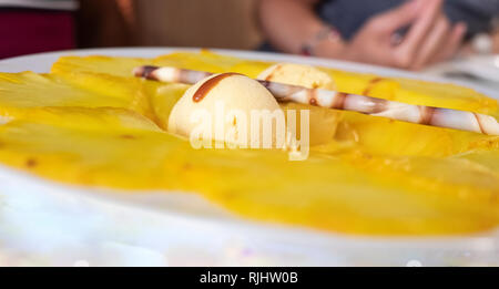 Crème glacée à la vanille avec carpaccio d'ananas et chocolat canutillo Banque D'Images