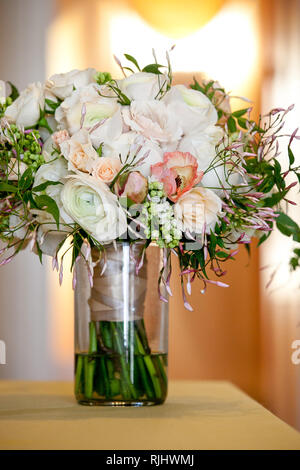 Une suite nuptiale mariage bouquet dans un pot de verre avant la cérémonie de mariage, des fleurs blanches et roses Banque D'Images