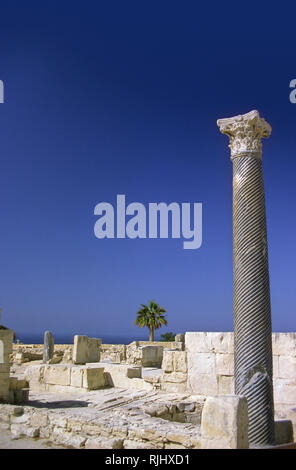 Colonne romaine dans l'Agora antique, Kourion, Episkopi, Limassol, Chypre : District Colonne solitaire contre un ciel bleu, avec palmier Banque D'Images