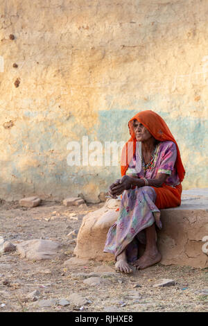 Une femme âgée de la tribu Bhil se trouve dans son village près de Bhainsrorgargh, Rajasthan, Inde. Banque D'Images