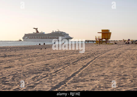 Un grand bateau de croisière est guidée dans le chenal menant au terminal des croisières au lever du soleil au large de South Beach, Miami Beach, Floride Banque D'Images