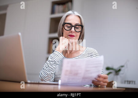 Femelle adulte mature payer facture en ligne à l'aide d'un ordinateur portable Banque D'Images