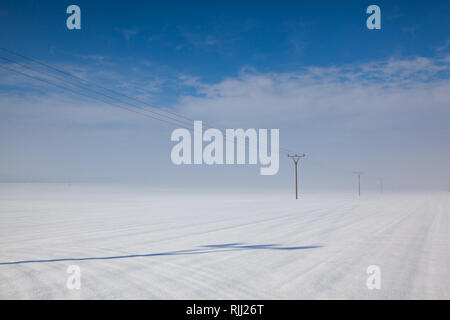 Paysage d'hiver avec des colonnes de la ligne d'alimentation d'un champ couvert de neige. Banque D'Images