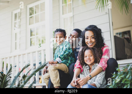 Portrait of African American family sitting outside home