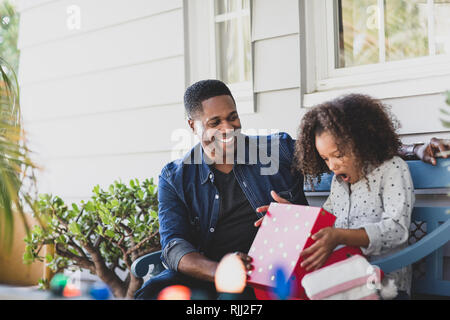 African American father giving daughter un cadeau de Noël Banque D'Images