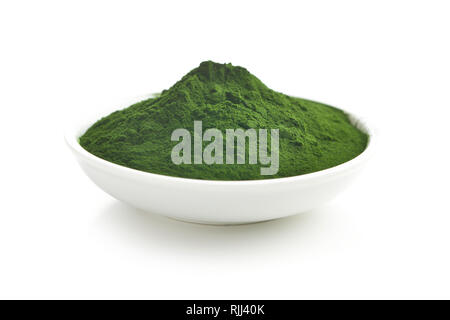La chlorelle vert ou vert en poudre dans un bol d'orge isolé sur fond blanc. Banque D'Images