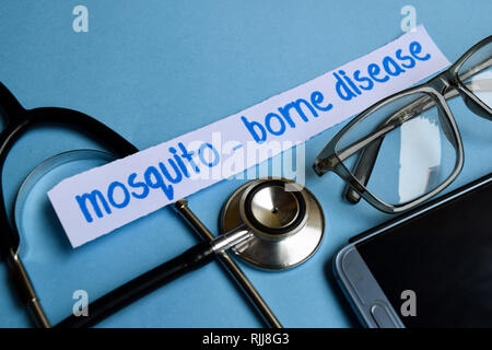 Image conceptuelle avec des maladies transmises par les moustiques - inscription à l'avis de stéthoscope, lunettes et smartphone sur le fond bleu. Medical co... Banque D'Images