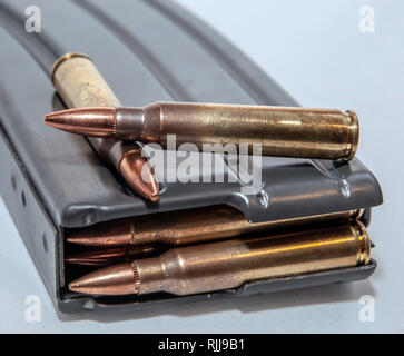 Magazine un fusil chargé avec des balles de calibre 223 avec deux balles sur le dessus de celui-ci sur un fond blanc Banque D'Images