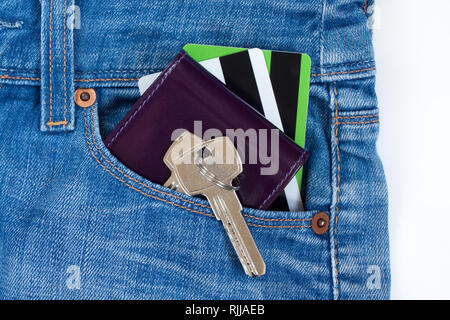 Porte-monnaie, cartes de crédit et les clés de la chambre sur un porte-clés sont situées dans une poche latérale de blue-jeans. Mode de vie moderne. Banque D'Images