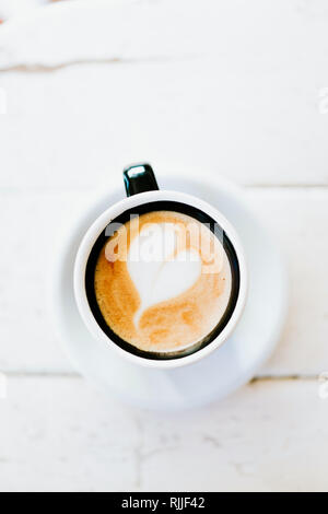 Petit café avec motif coeur dans une coupe rétro Banque D'Images