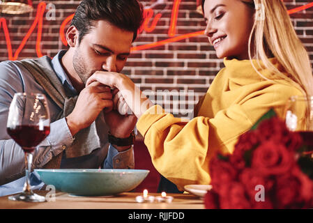 Baiser ses mains pour toujours. Couple love story - bel homme jeune embrasse la main de femme avec passion. Le concept de relation avec copain et copine tog Banque D'Images