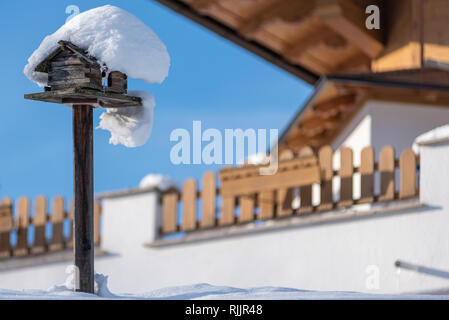 Home-made de l'oiseau en bois convoyeur en hiver, sous la neige. Banque D'Images