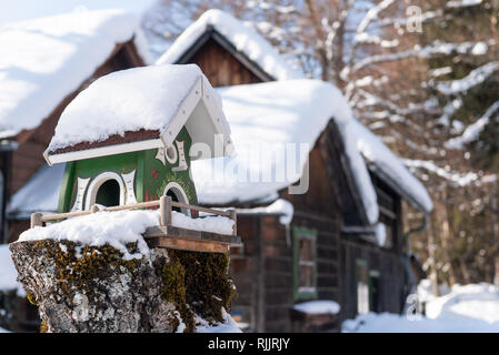 Home-made de l'oiseau en bois convoyeur en hiver, sous la neige. Banque D'Images