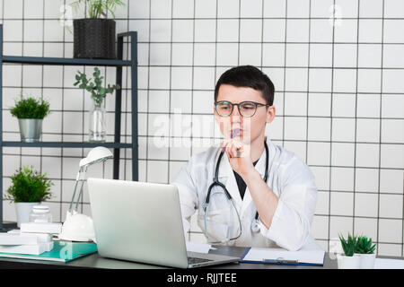 Beau jeune médecin travaillant la nuit à l'hôpital Banque D'Images