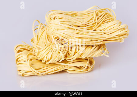 Nouilles laminées sèches d'épaisseur de forme carrée. Capelli d'angelo, les cheveux d'Ange - pâtes. Les pâtes italiennes tagliatelles faites maison. La cuisine italienne. Les nouilles aux oeufs. Banque D'Images