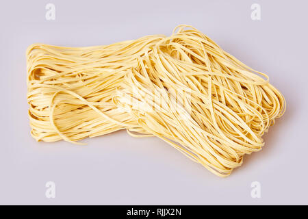 Nouilles laminées sèches d'épaisseur de forme carrée. Capelli d'angelo, les cheveux d'Ange - pâtes. Les pâtes italiennes tagliatelles faites maison. La cuisine italienne. Les nouilles aux oeufs. Banque D'Images