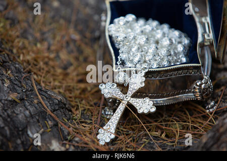 croix de mariage en argent sur le sol Banque D'Images