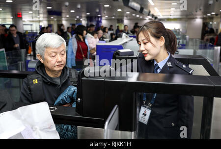 Qingdao, Chine, la province de Shandong. Feb 6, 2019. Policewoman Soleil Wenjing (R) aide un homme âgé obtenir effacée au point de contrôle de l'immigration de l'aéroport de Qingdao, province de Shandong en Chine orientale, le 6 février 2019. Les agents de police de l'immigration au point de contrôle d'inspection de l'aéroport de Qingdao étaient de service comme d'habitude au cours de la Nouvelle Année lunaire chinoise. Credit : Xie Hao/Xinhua/Alamy Live News Banque D'Images