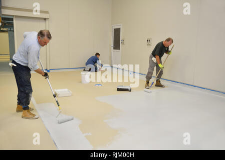 La dernière couche de roulement de métier d'epoxy produit sur le plancher d'un bâtiment industriel Banque D'Images