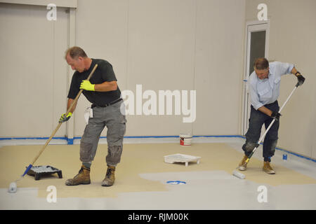 La dernière couche de roulement de métier d'epoxy produit sur le plancher d'un bâtiment industriel Banque D'Images