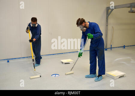 La dernière couche de roulement de métier d'époxy clair produit sur le plancher d'un bâtiment industriel Banque D'Images