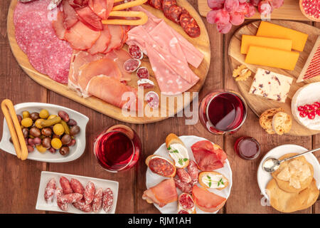 Charcuterie gastronomique. Un assortiment de saucisses et de jambons, charcuteries, et une assiette de fromage, tourné à partir de ci-dessus, sur un fond rustique avec du vin et des olives Banque D'Images