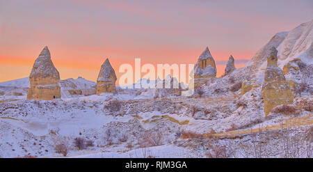 Lever du soleil sur les rochers en Cappadoce (vallée des pigeons) à la suite d'une chute de neige légère. Tout couvert de neige d'un blanc pur au petit matin sous lig Banque D'Images