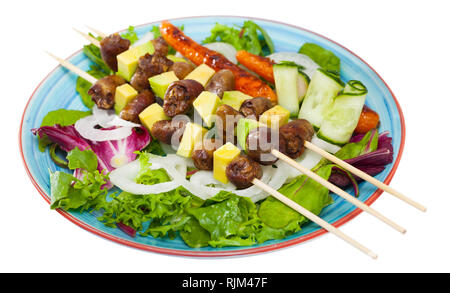 Brochettes de coeur de poulet appétissant avec avocat frais servi avec des carottes sur coussin d'oignons verts et mixtes. Plus isolé sur fond blanc Banque D'Images