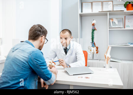 Portrait d'un thérapeute principal pendant la consultation médicale modèle anatomique montrant des vertèbres dans le bureau Banque D'Images