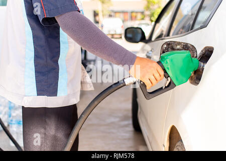 Libre main tenant le pistolet pour faire le plein d'huile pour voiture en station-service. Banque D'Images