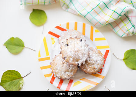 Cupcakes colorés sur une plaque avec des feuilles vertes, close-up Banque D'Images