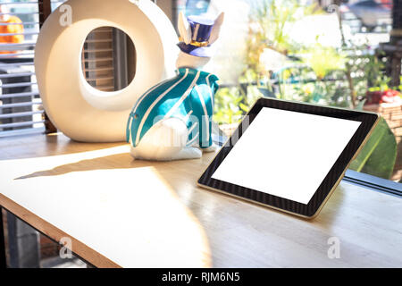 Tablette numérique avec écran vide sur la table en bois dans la région de coffee shop. Banque D'Images