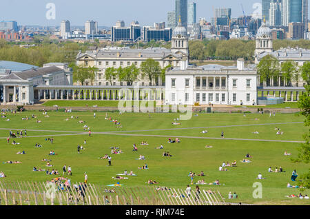 Des foules de gens se coucher sur l'herbe et profiter du soleil et de la chaleur pendant une vague dans le parc de Greenwich, Londres, Angleterre. Banque D'Images