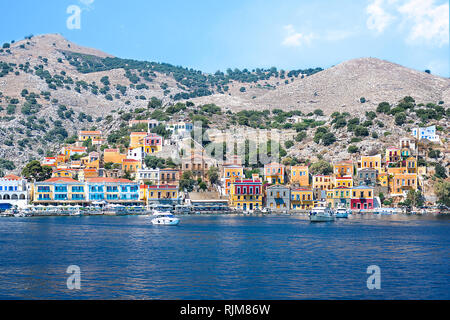 Bateaux à moteur et des maisons colorées au port de Symi (île de Symi, Grèce) Banque D'Images