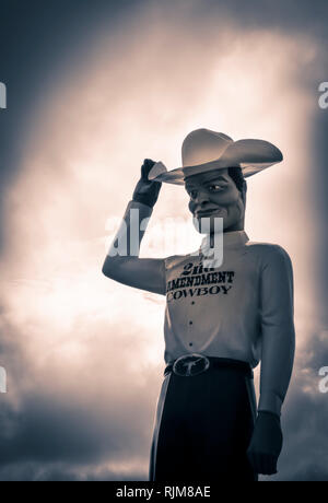 Une sculpture géante d'un cow-boy vêtu d'un "deuxième amendement Cowboy' shirt, basculant la 10 gallons stetson comme Roadside Attraction près de Amarillo, TX Banque D'Images