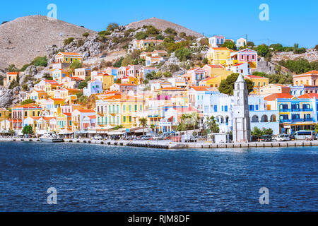 Clocher et maisons néoclassiques colorées dans la ville portuaire de Symi (île de Symi, Grèce) Banque D'Images